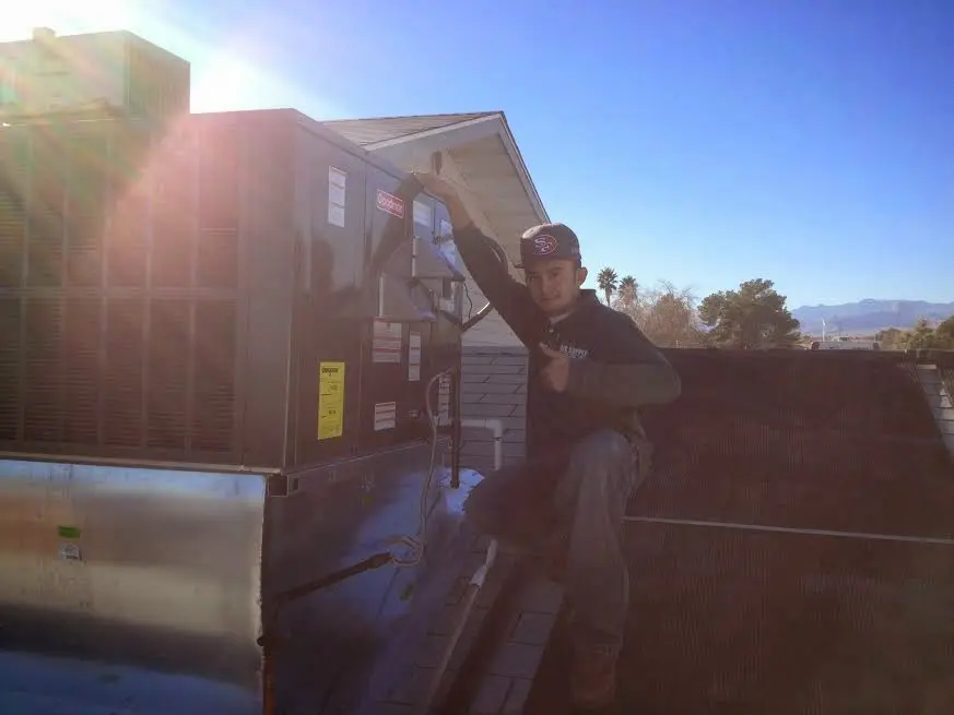 HVAC technician performing AC Tune-Up on a rooftop unit in Okeechobee